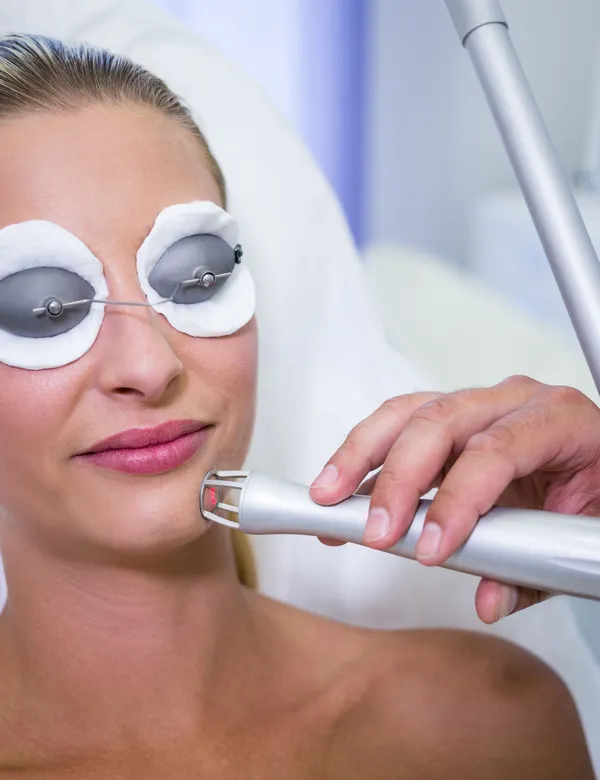 Client with protective eye pads receiving a laser treatment on the face in St. Petersburg FL